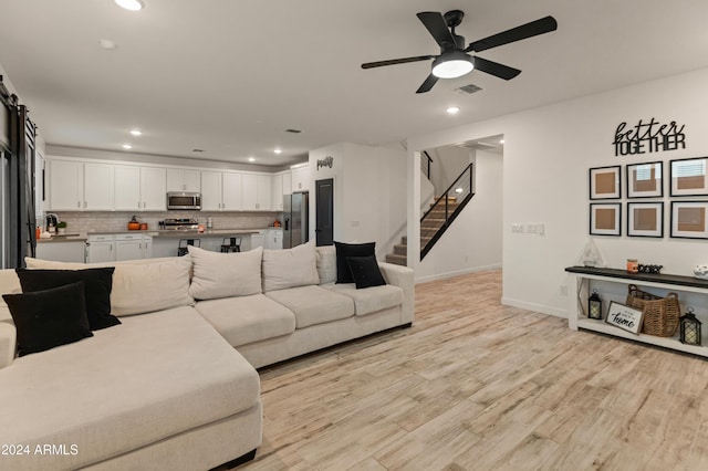 16848 W Alice Ave, Waddell, AZ 85355 - living room featuring stairs, ceiling fan, light wood finished floors, recessed lighting, and baseboards