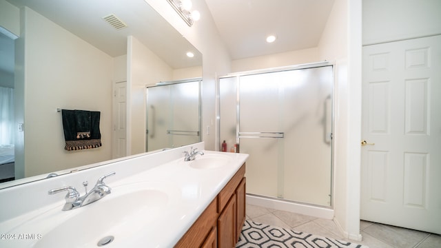 bathroom featuring vanity, tile patterned flooring, and a shower with shower door