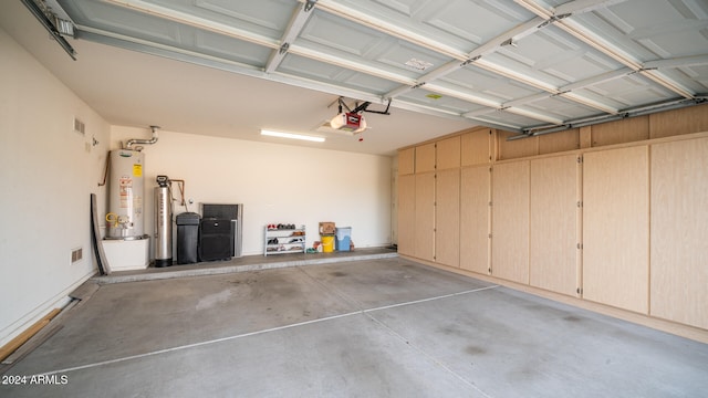 garage featuring water heater and a garage door opener