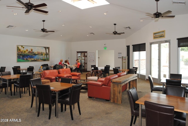 carpeted dining area featuring high vaulted ceiling