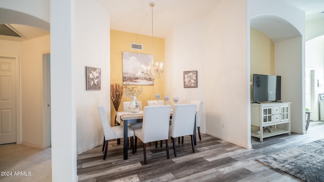 dining space featuring wood-type flooring and a notable chandelier