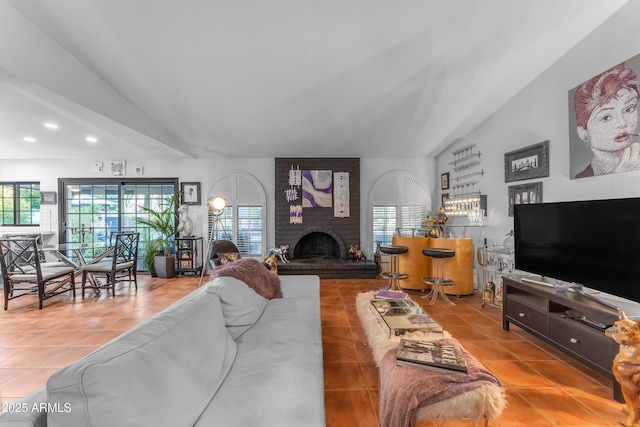 tiled living room with lofted ceiling, a fireplace, and bar