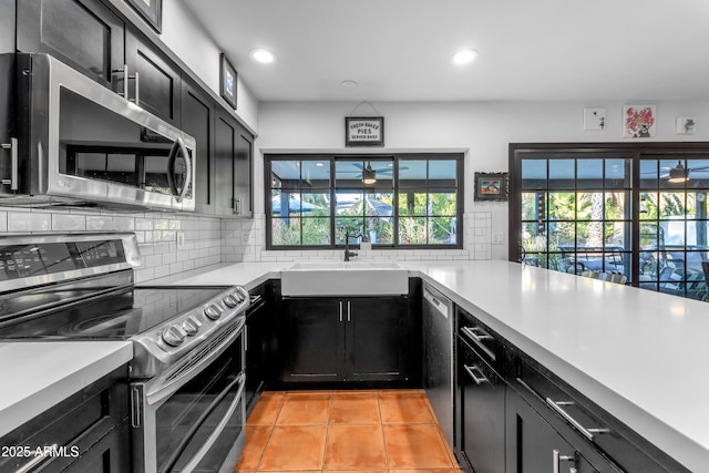 kitchen featuring tasteful backsplash, appliances with stainless steel finishes, sink, and light tile patterned floors