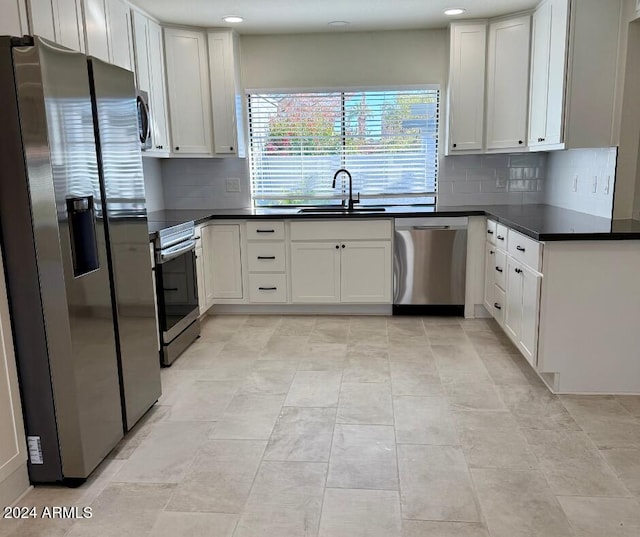 kitchen featuring sink, stainless steel appliances, light tile patterned floors, decorative backsplash, and white cabinets