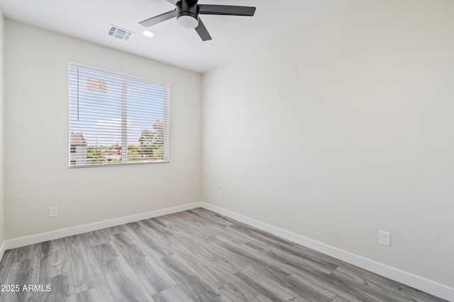 spare room with visible vents, baseboards, ceiling fan, and wood finished floors