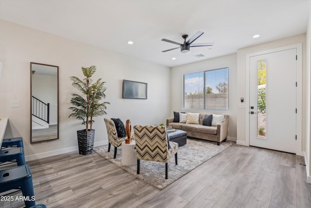 living room featuring a ceiling fan, visible vents, wood finished floors, baseboards, and recessed lighting