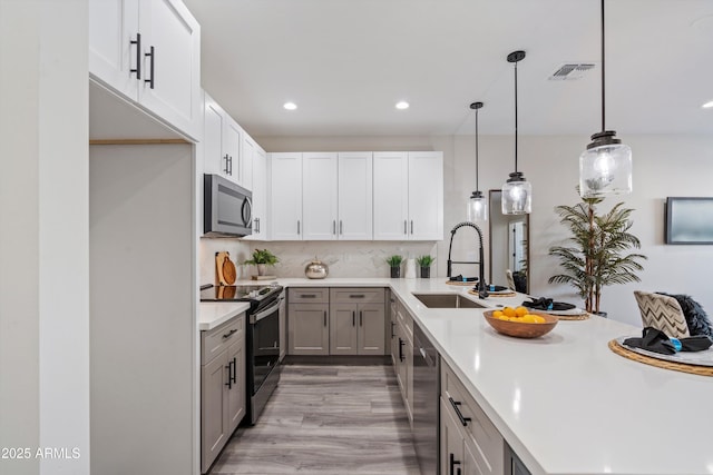 kitchen with visible vents, a sink, light countertops, stainless steel appliances, and recessed lighting