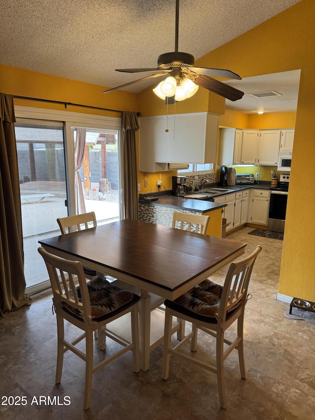12512 N 85th Ave, Peoria, AZ 85381 - dining room with ceiling fan, a textured ceiling, and lofted ceiling