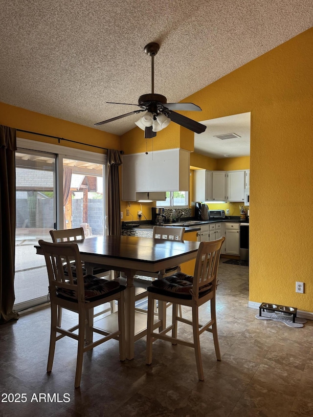 12512 N 85th Ave, Peoria, AZ 85381 - dining room with a textured wall, ceiling fan, a textured ceiling, and lofted ceiling