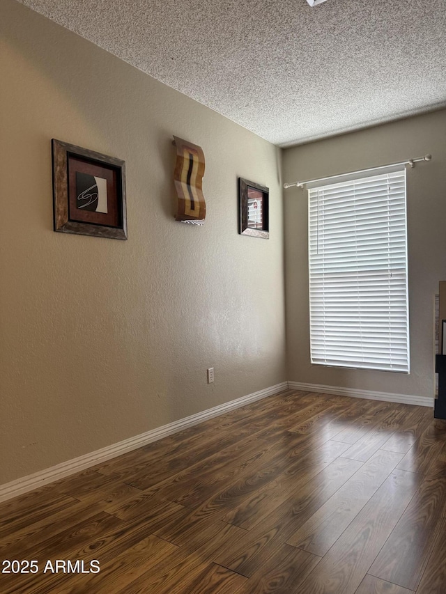 12512 N 85th Ave, Peoria, AZ 85381 - empty room with a textured ceiling, baseboards, and dark wood-style floors