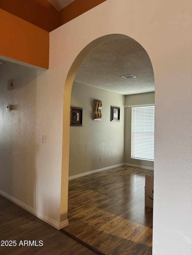12512 N 85th Ave, Peoria, AZ 85381 - corridor with arched walkways, wood finished floors, baseboards, and a textured ceiling