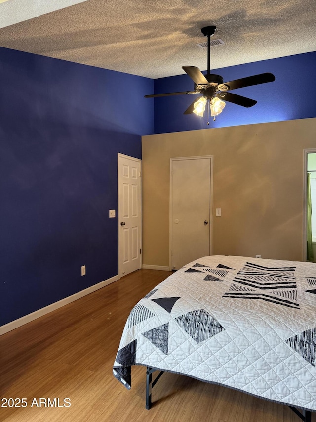 12512 N 85th Ave, Peoria, AZ 85381 - bedroom featuring wood finished floors, a textured ceiling, ceiling fan, and baseboards