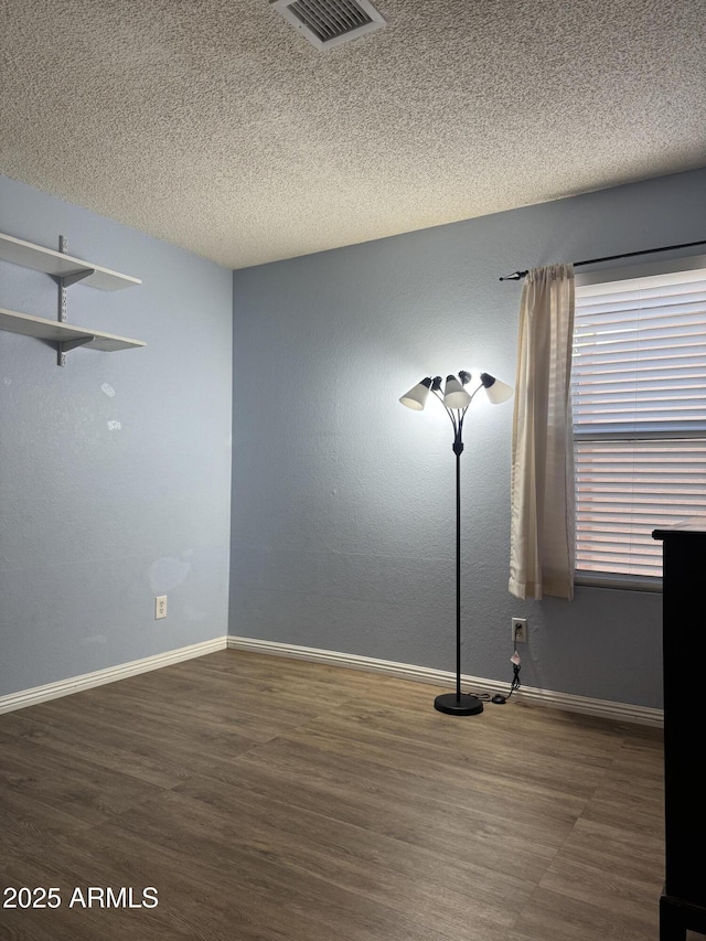 12512 N 85th Ave, Peoria, AZ 85381 - empty room with wood finished floors, a textured ceiling, and baseboards