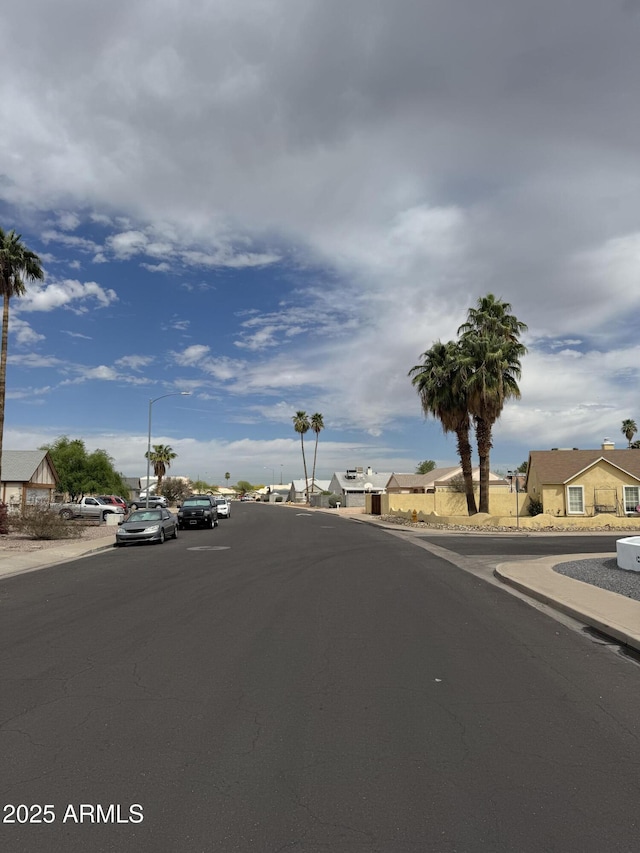 12512 N 85th Ave, Peoria, AZ 85381 - view of asphalt road featuring curbs, street lighting, sidewalks, and a residential view