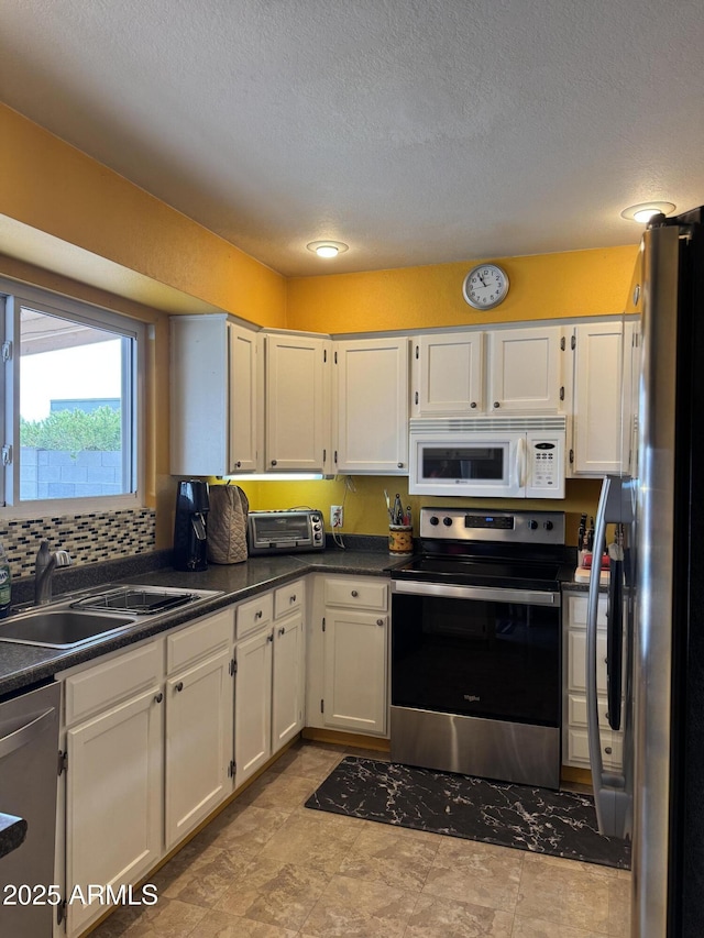 12512 N 85th Ave, Peoria, AZ 85381 - kitchen featuring appliances with stainless steel finishes, white cabinets, dark countertops, a textured ceiling, and a sink