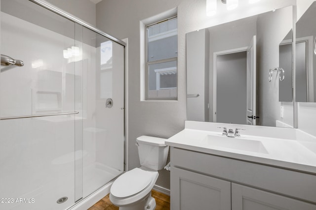 bathroom with toilet, hardwood / wood-style floors, an enclosed shower, and oversized vanity