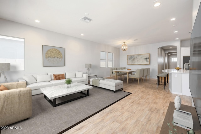 living room featuring light hardwood / wood-style floors and a notable chandelier