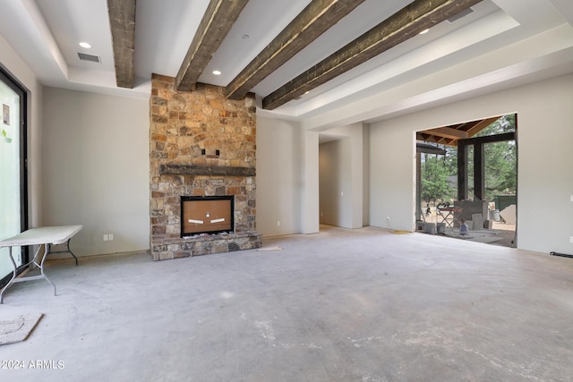 unfurnished living room featuring beam ceiling and a fireplace