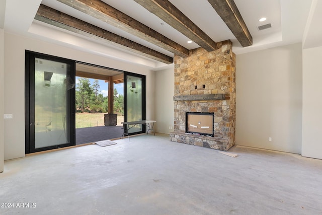 unfurnished living room featuring a stone fireplace, concrete floors, and beamed ceiling