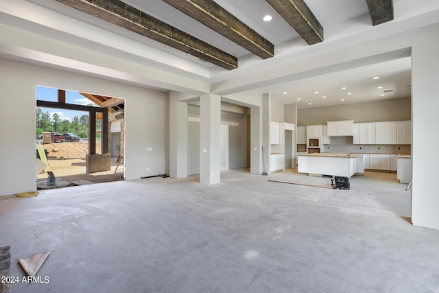 unfurnished living room featuring beamed ceiling