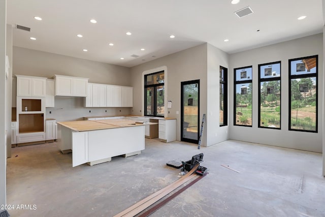 kitchen with a breakfast bar, white cabinetry, and a center island