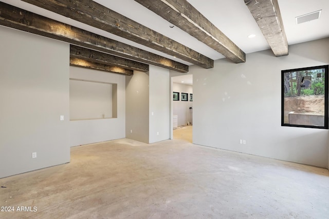 empty room featuring beam ceiling