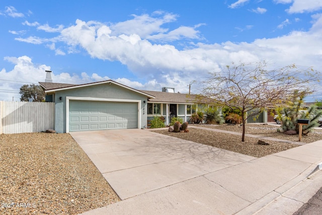 ranch-style house featuring fence, concrete driveway, stucco siding, a chimney, and an attached garage