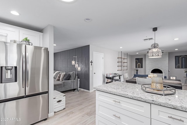 kitchen featuring open floor plan, recessed lighting, stainless steel fridge, and light wood-type flooring