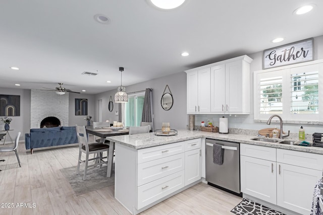 kitchen featuring a ceiling fan, a sink, a peninsula, white cabinets, and dishwasher