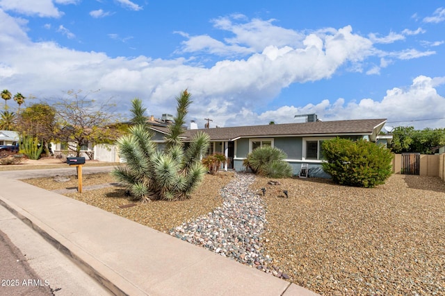 view of front facade featuring concrete driveway, an attached garage, fence, and stucco siding