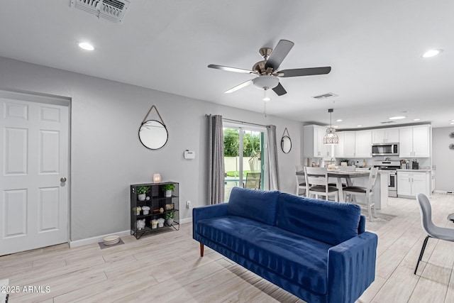 living area with recessed lighting, visible vents, a ceiling fan, and light wood finished floors