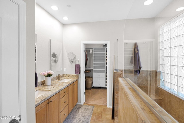 2452 W Muirfield Dr, Anthem, AZ 85086 - bathroom featuring double vanity, a sink, a spacious closet, and walk in shower