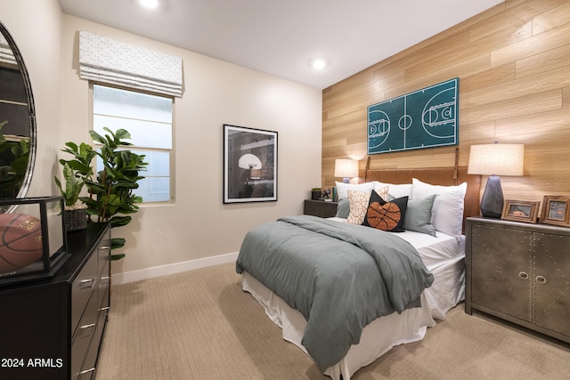 bedroom with recessed lighting, light colored carpet, an accent wall, wood walls, and baseboards