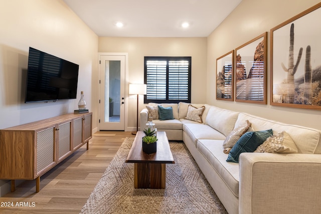 living room with baseboards, recessed lighting, and light wood-style floors