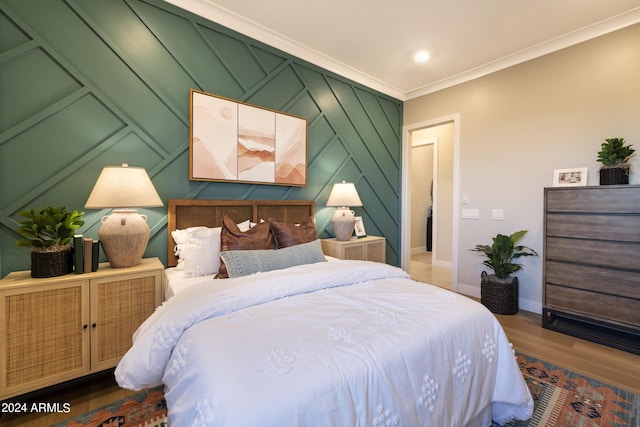 bedroom with baseboards, ornamental molding, and wood finished floors