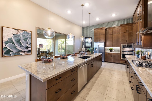 kitchen featuring pendant lighting, a large island, glass insert cabinets, a sink, and built in appliances