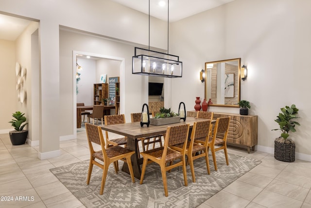 dining area featuring a high ceiling, baseboards, and light tile patterned floors