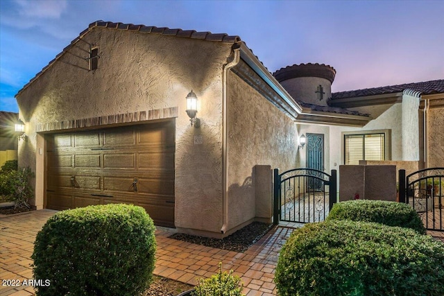 property exterior at dusk featuring a garage