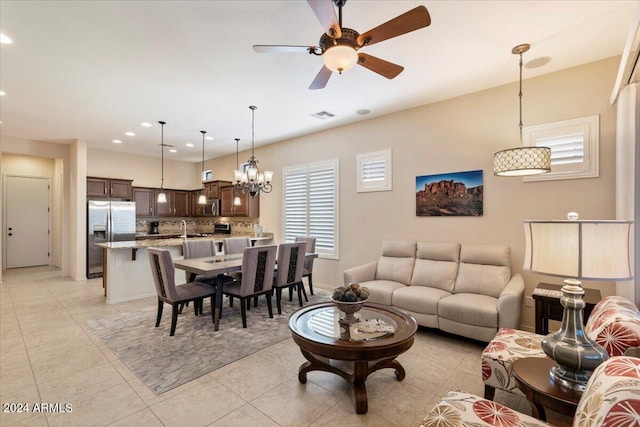 living room featuring sink, ceiling fan with notable chandelier, and light tile patterned floors