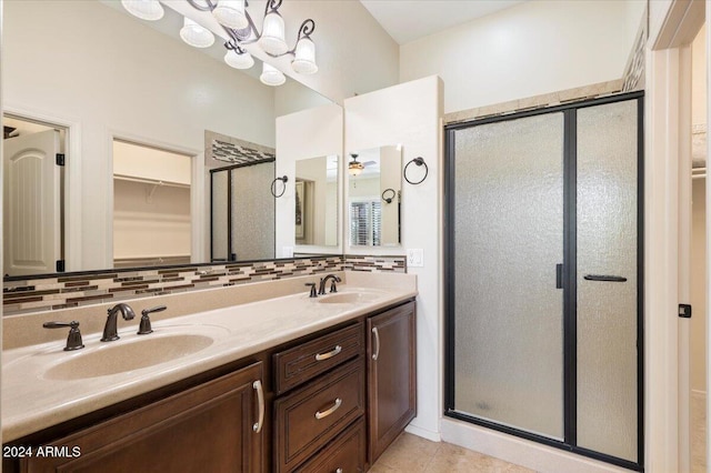 bathroom with a shower with door, vanity, tasteful backsplash, and tile patterned flooring