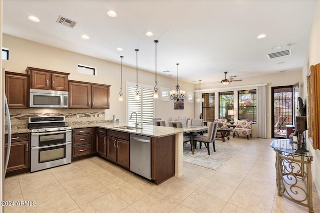 kitchen featuring sink, decorative light fixtures, stainless steel appliances, and kitchen peninsula