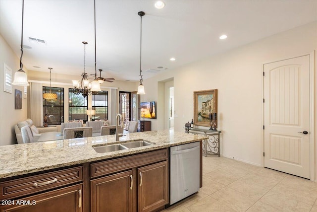 kitchen featuring stainless steel dishwasher, sink, light stone counters, and pendant lighting