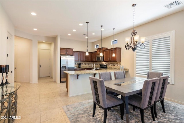 dining area with sink, a chandelier, and light tile patterned floors