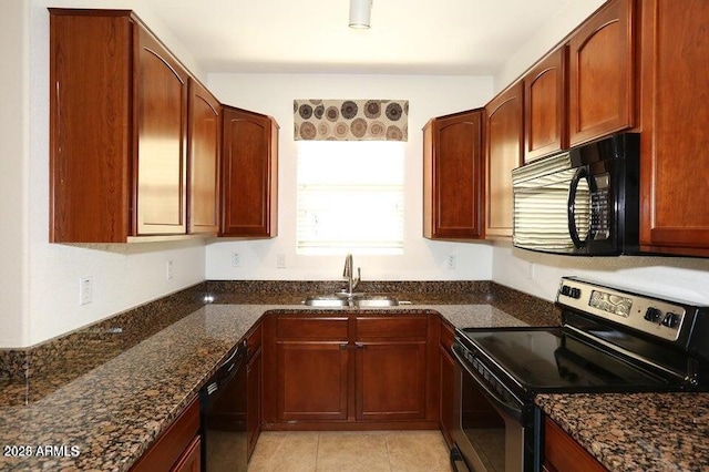 kitchen with sink, light tile patterned floors, black appliances, and dark stone counters