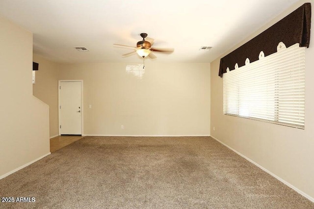 carpeted spare room with ceiling fan