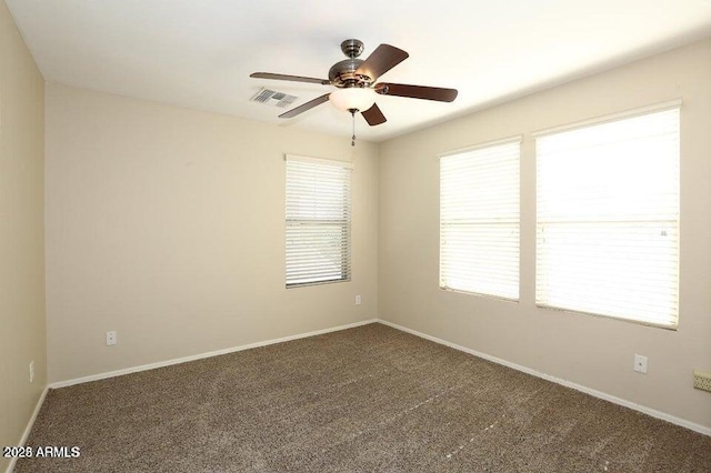 empty room with ceiling fan and dark carpet