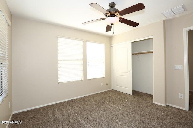 unfurnished bedroom with ceiling fan, a closet, and dark colored carpet