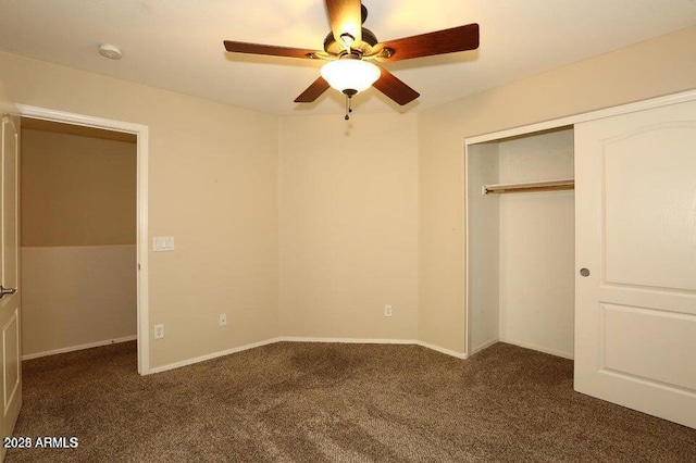 unfurnished bedroom with ceiling fan and dark carpet