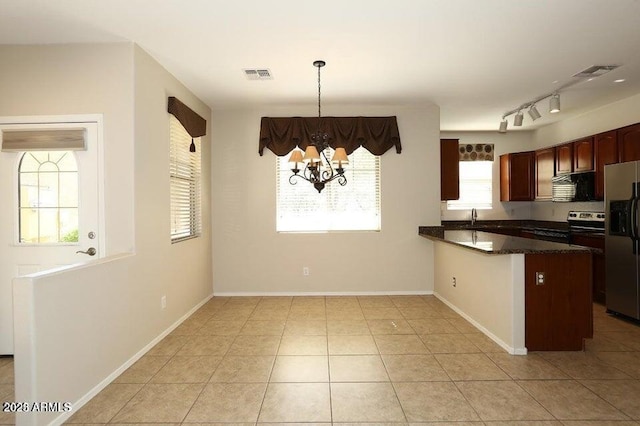 kitchen with a wealth of natural light, hanging light fixtures, kitchen peninsula, and stainless steel appliances