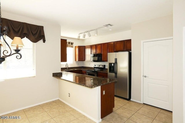 kitchen with kitchen peninsula, appliances with stainless steel finishes, sink, light tile patterned floors, and dark stone countertops